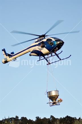 Hughes helicopter carrying a monsoon bucket - in this case loaded with 1080.