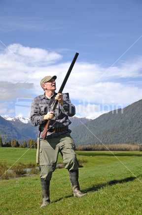 Hunter scans the sky for ducks, West Coast, South Island