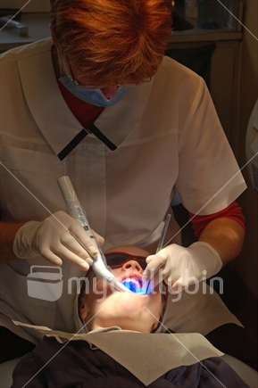 School dental nurses at work on a girl's tooth. Free dental care is provided for all children in New Zealand. On the West Coast the nurses work in a portable dental surgery.