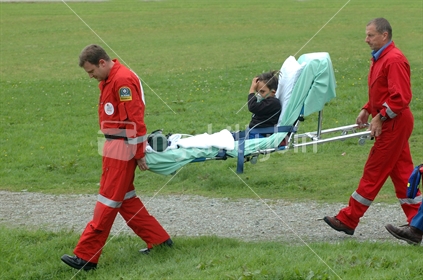 stretcher bearers carry patient to Rescue Helicopter, West Coast