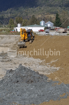 10 ton digger smooths out clay for lining an effluent pond next to a rotary dairy in Westland
