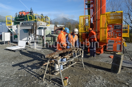 Drilling crewmen prepare to remove a core sample from a rig drilling near Greymouth, West Coast