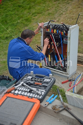 Electrician wiring up a building to a mains power supply