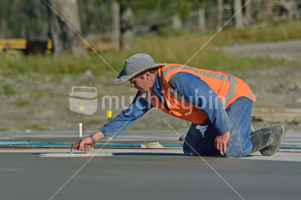 A builder floating off new concrete for a large building near Greymouth, 