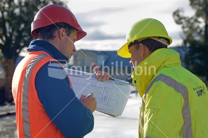 Builders discuss plans at the construction site