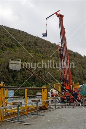 Drillers load a new pipe onto the drillstring while drilling to 1300 metres on the Deep Fault Drilling Project, Whataroa, South Island on December 5, 2014. 
