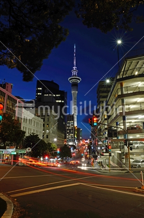 Vehicles pass the Sky Tower in Auckland's central business district on a summer's evening