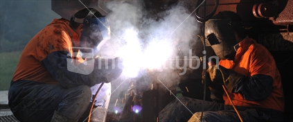 Men on the West Coast, South Island, welding the pre-collar pipe on a rig drilling for coal seam gas, 