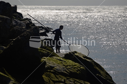 A man fishes for whitebait on the Grey River, West Coast