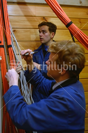 Electricians label wires before wiring up a switchboard in a new building