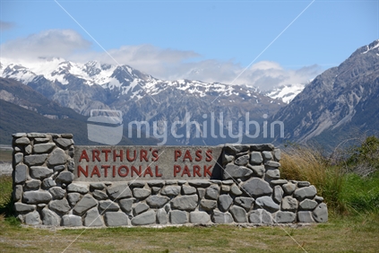 A rock wall sign for the Arthurs Pass National Park near the Bealey Bridge and the Waimakariri River in Canterbury, New Zealand