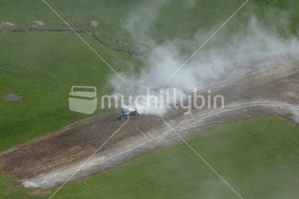 Aerial of a tractor spreading lime on a West Coast dairy farm