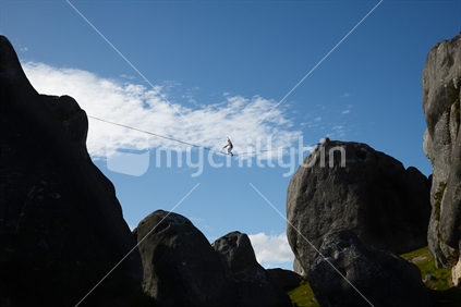 An unidentified adventurer tries some rope walking among the limestone outcrops at Castle Hill, South Island, New Zealand
