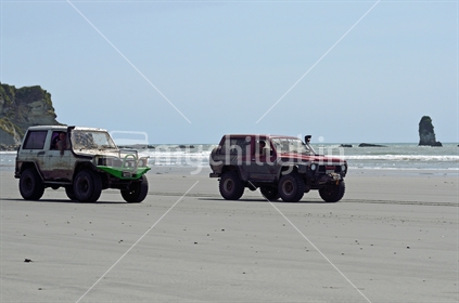 A couple of four wheel drive enthusiasts enjoy a spin on Rapahoe Beach near Greymouth