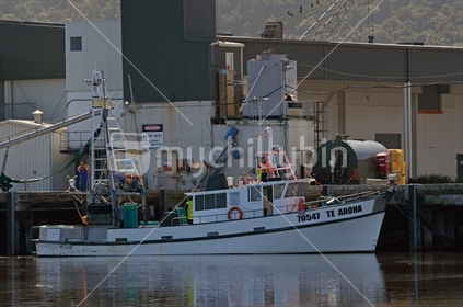 A small fishing vessel unloads its catch at the Greymouth Wharf
