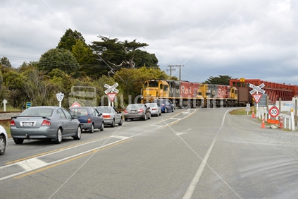 A freight train holds up traffic at the historic road-rail bridge across the Taramakau River near Greymouth, New Zealand
