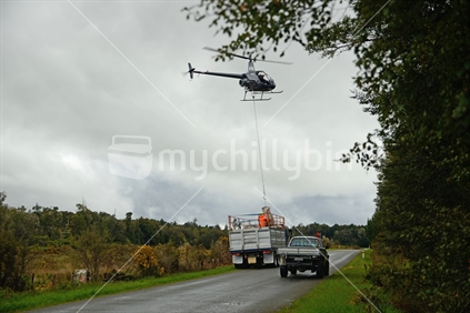 A light helicopter carries bags of sphagnum moss from a swamp near Lake Haupiri to a truck on the roadside. West Coast  sphagnum moss is harvested sustainably and used in horticulture.