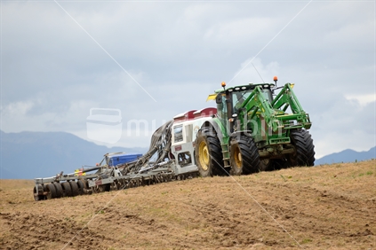 An air seeder used for sowing seed on old pasture, West Coast. The harrows and tyres will settle the seed for good germination.