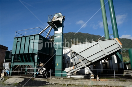 An engineer feeds coal into the hopper that fuels a boiler for a rendering plant