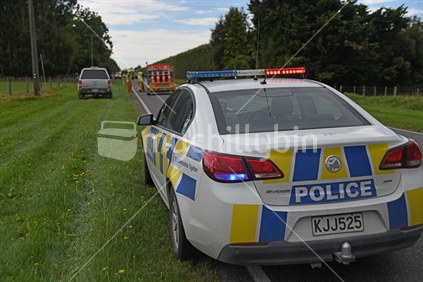 CHRISTCHURCH, NEW ZEALAND, DECEMBER 14, 2018: A police car waits on the roadside near a single vehicle accident