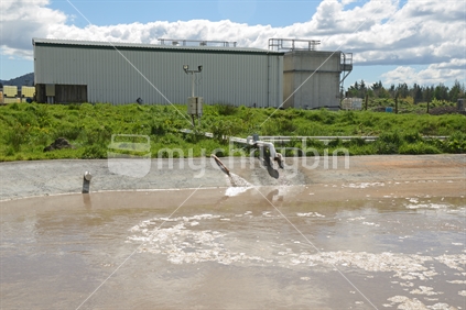 A holding pond uses aeration to remove pollutants from industrial waste water