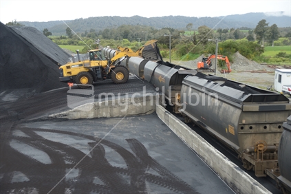 STILLWATER, NEW ZEALAND, OCTOBER 25, 2019: A payloader fills train wagons with coal at the siding at Stillwater, West Coast, New Zealand