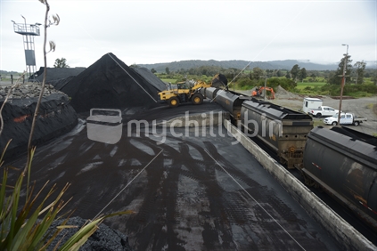 STILLWATER, NEW ZEALAND, OCTOBER 25, 2019: A payloader fills train wagons with coal at the siding at Stillwater, West Coast, New Zealand