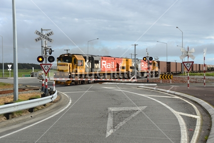 ARAHURA, NEW ZEALAND, AUGUST 29, 2020: A freight train crosses the main road at Arahura on State Highway 6.