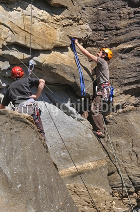 Tutor instructs a young man climbing "Racing in the Streets" on the Wonderwall at Charleston, West Coast, New Zealand.
