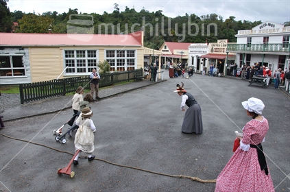 Children in period costume racing their hobby horses  in an event at Shantytown, Westland