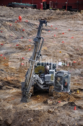 Machine drilling holes for explosive charges to remove mine overburden, South Island, New Zealand. 