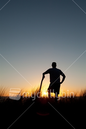 A silhouetted man watching the sunset at the beach  1