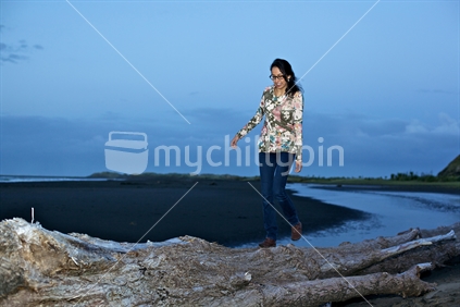 Balancing on the log; Whatipu beach, West Coast, New Zealand. 