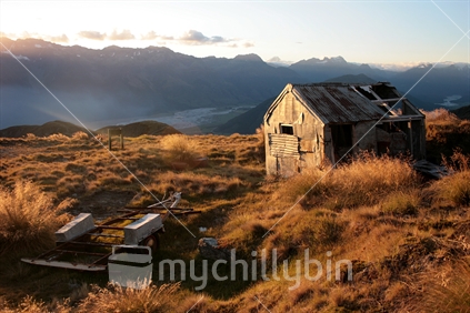 Sunset over the Humboldt Mountains from Mt Mcintosh on part of the Whakaari tramping tracks, with and old scheelite miner's hut in the foreground.