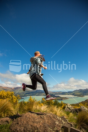 Girl jumping over rocks