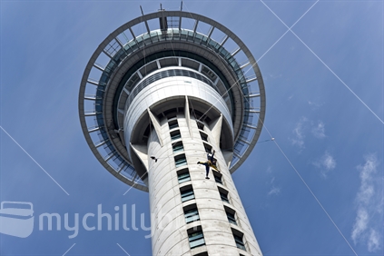 Sky Tower, with a person in mid air doing the jump