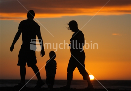 Family on a Whanganui beach at sunset.