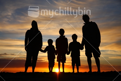 Silhouette family on a New Zealand beach at sunset