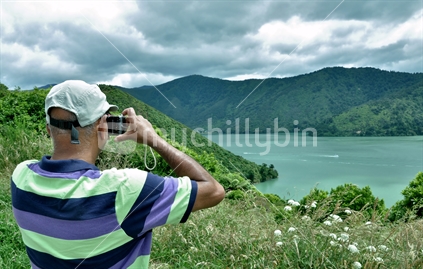 Indian tourist taking in the scenery of the unreal Mahau Sound in the Marlborough Sound, South Island