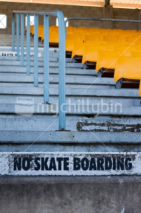 No skateboarding sign painted onto steps with handrail in background.