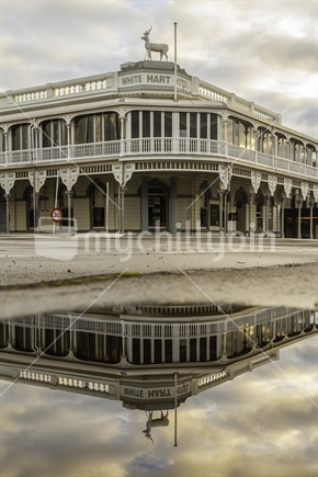 New Plymouth's White Hart Hotel reflected in a puddle.