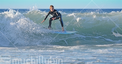 Teenager surfing in Taranaki, New Zealand. 