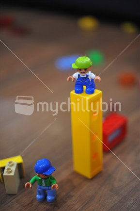 Toy man with cap on sideways directing activities below.
