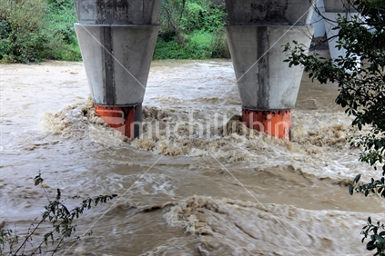 WAIKANAE, WELLINGTON - 14 MAY - Waikanae River surges with flood waters rushing past bridge supports during extreme rainfall, 14 May 2015