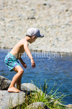 Young Boy jumping into a river on a sunny summer day (motion blur)