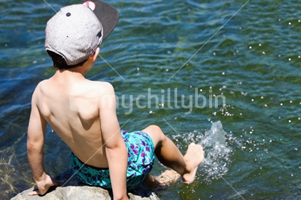Young Boy jumping into a river on a sunny summer day (motion blur)