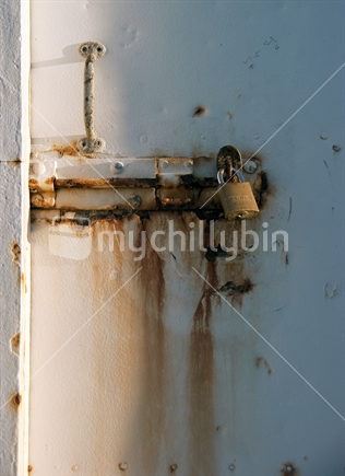 Rusted metal door and lock. Boulder Bank lighthouse, Nelson