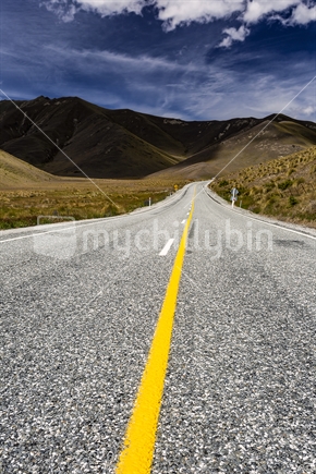 Yellow road marking leads to Lindis Pass, Central Otago