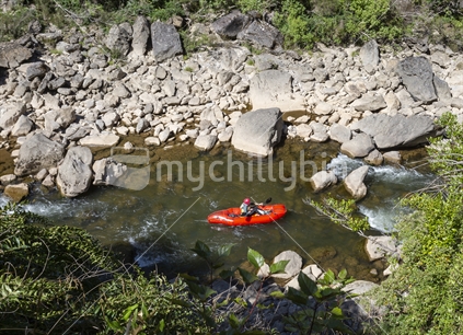 Red inflatable pack raft on the Matiri River, Kahurangi National Park