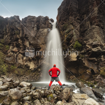 Red tramper admires the symmetrical Taranaki Falls, Mt Ruapehu, Tongariro National Park, person, visitor, tourist, tramper, hiker, red, man, male, guy